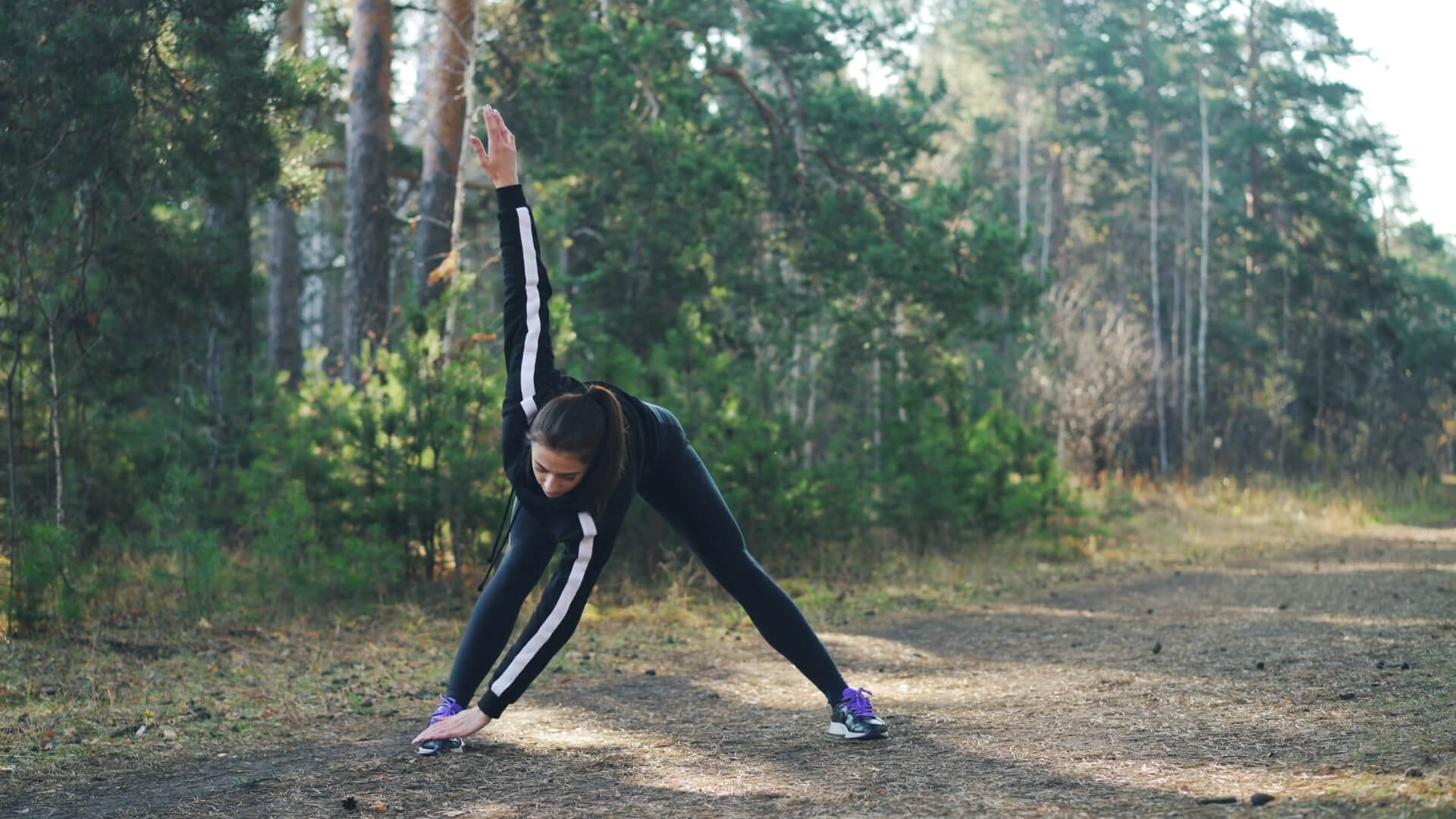 The girl is exercising outdoors